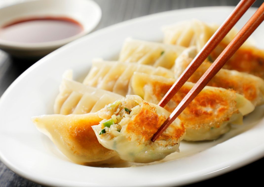  En lækker, stegt gyoza holdes i et par spisepinde