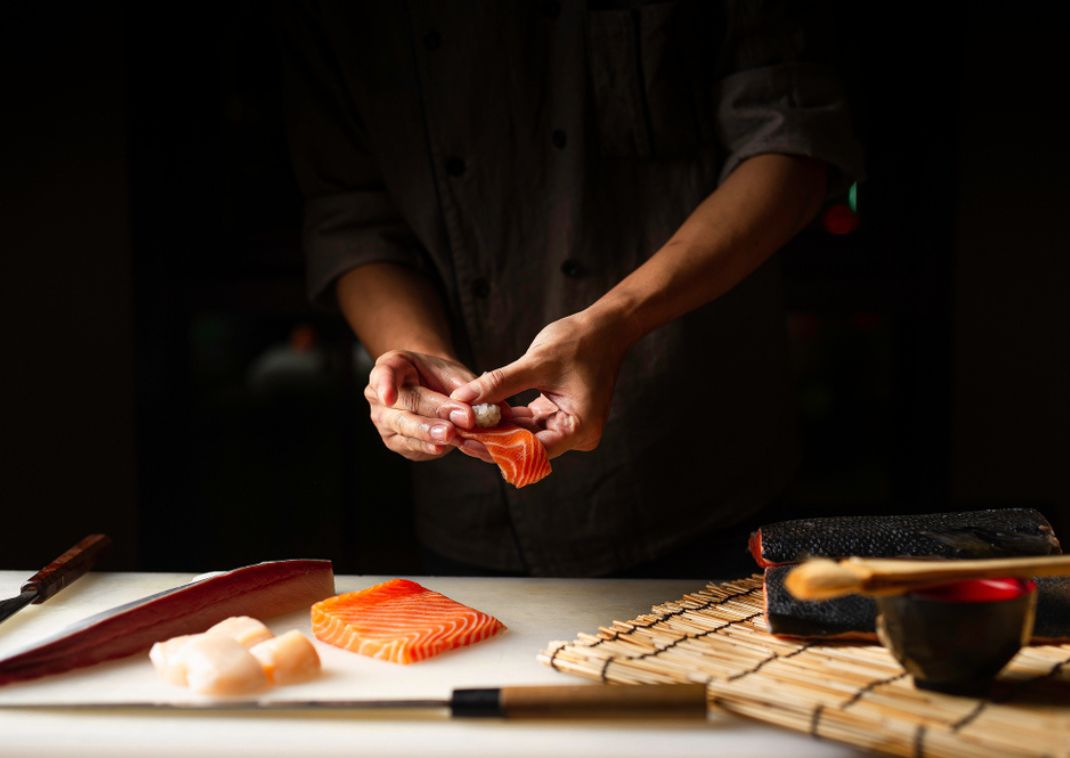 Japansk kok tilbereder frisk sushi i Japan.