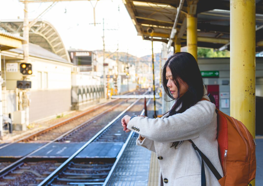 Kvinde ser på hendes ur, på en togstation i Japan