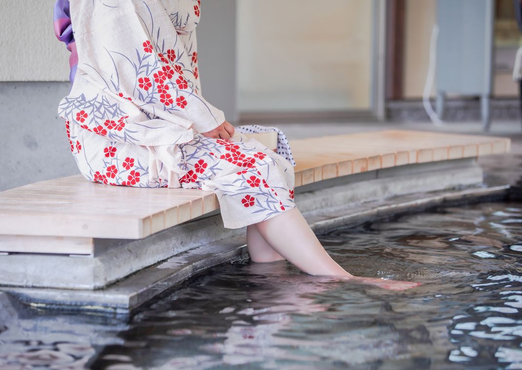 Kvinde i yukata nyder et fodbad i Japan