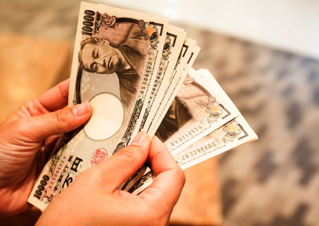 En person tæller en stor stak japanske Yen