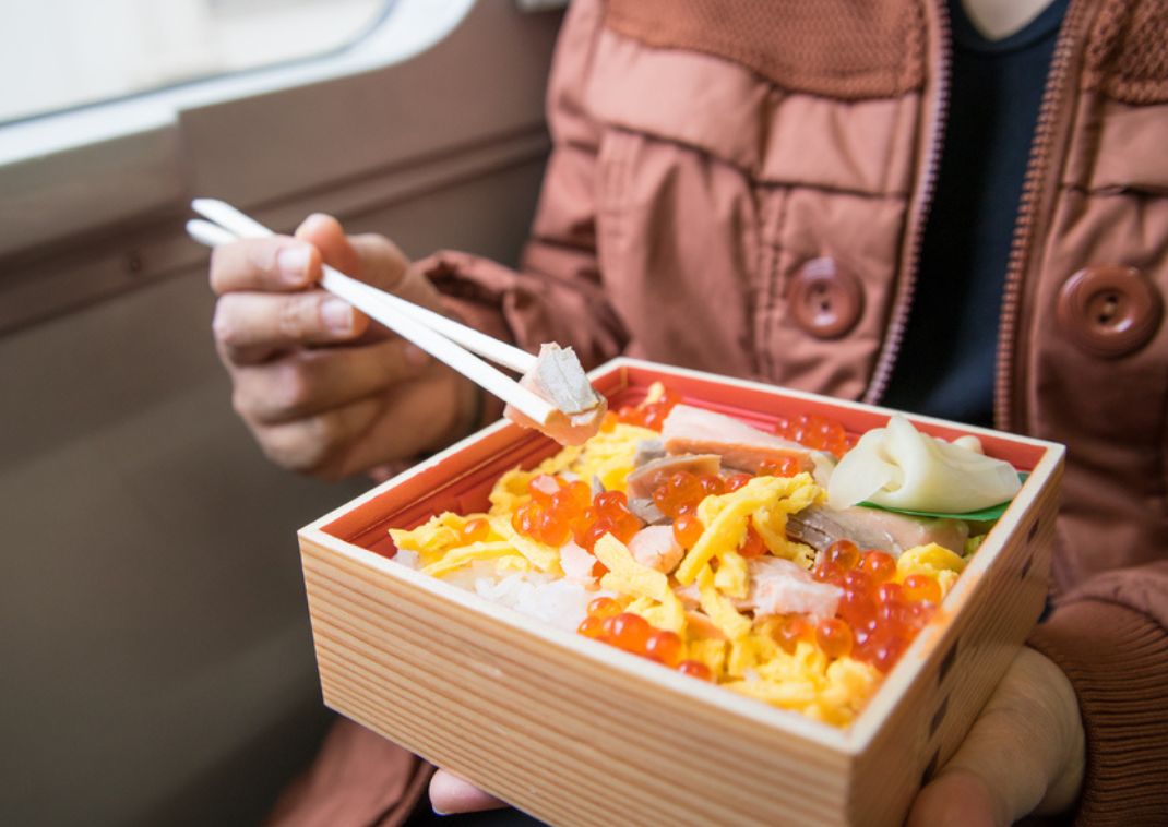 turist, der spiser japansk bento-mad, træ