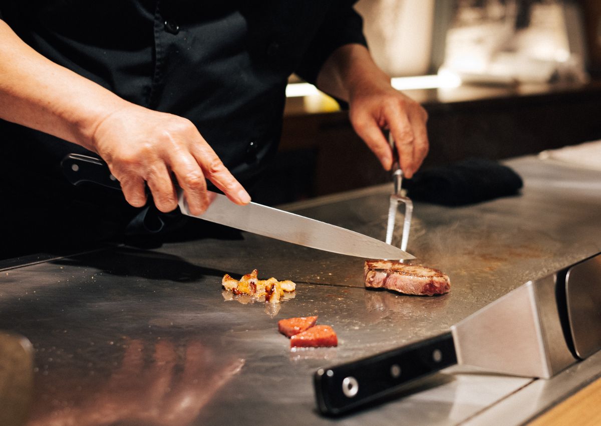 Kok skærer Kobe-bøf på teppanyaki-grill