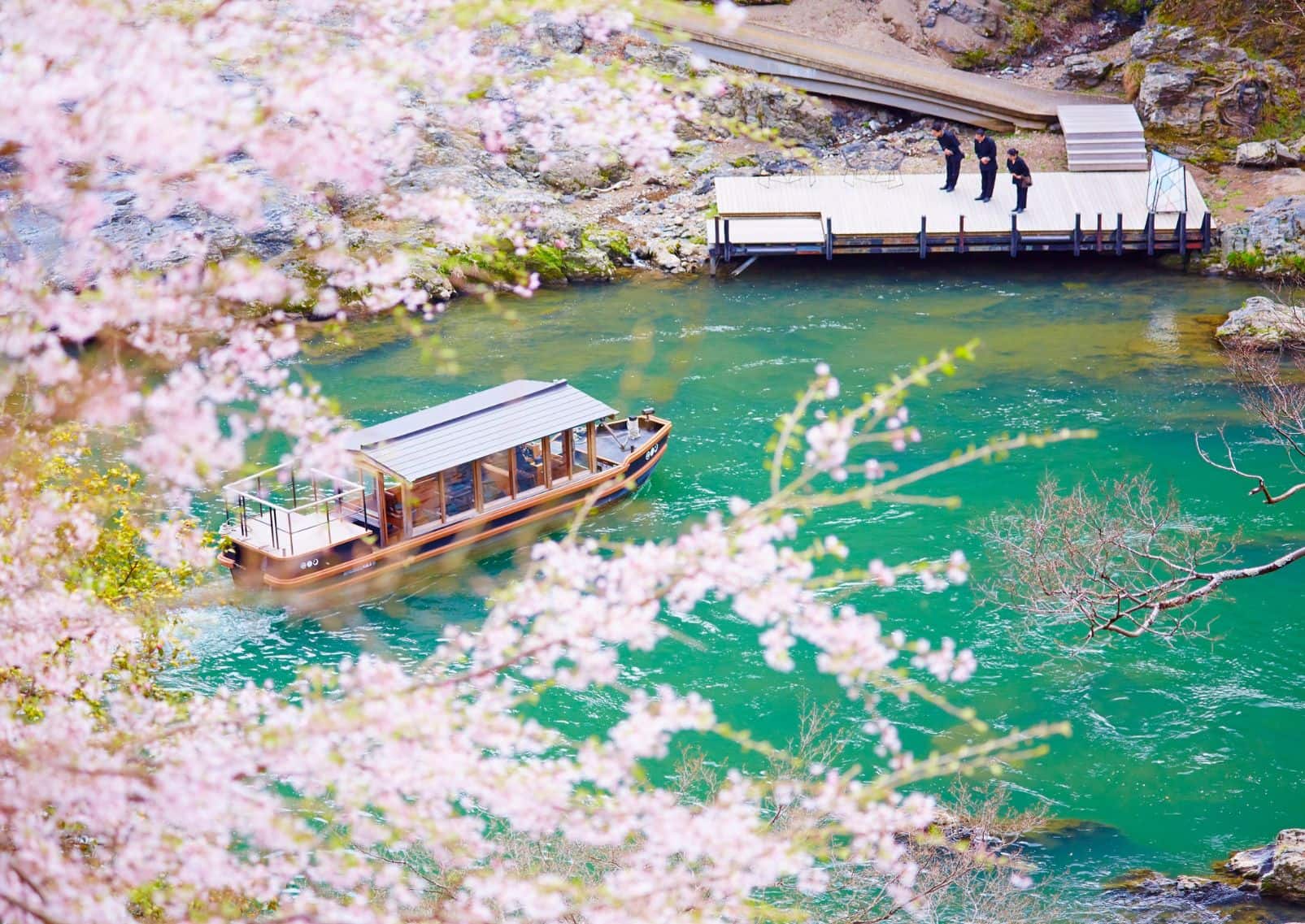 Båd ankommer til Hoshinoya Kyoto, modtaget af personalet
