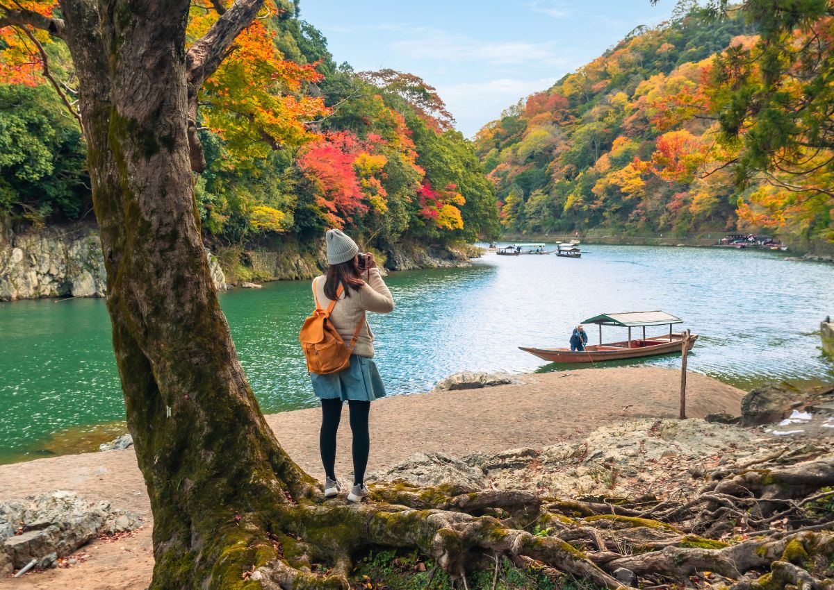 Rejsende fotograferer efterårsfarverne i Arashiyama i Kyoto.