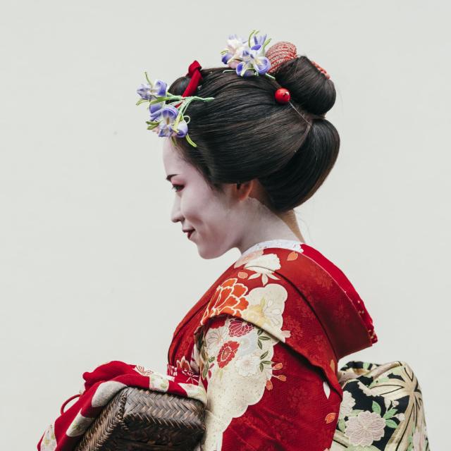 Geisha poserer foran en grå baggrund