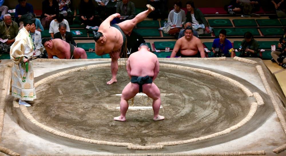 Japanske sumobrydere forbereder sig på en kamp i ringen iført traditionel mawashi