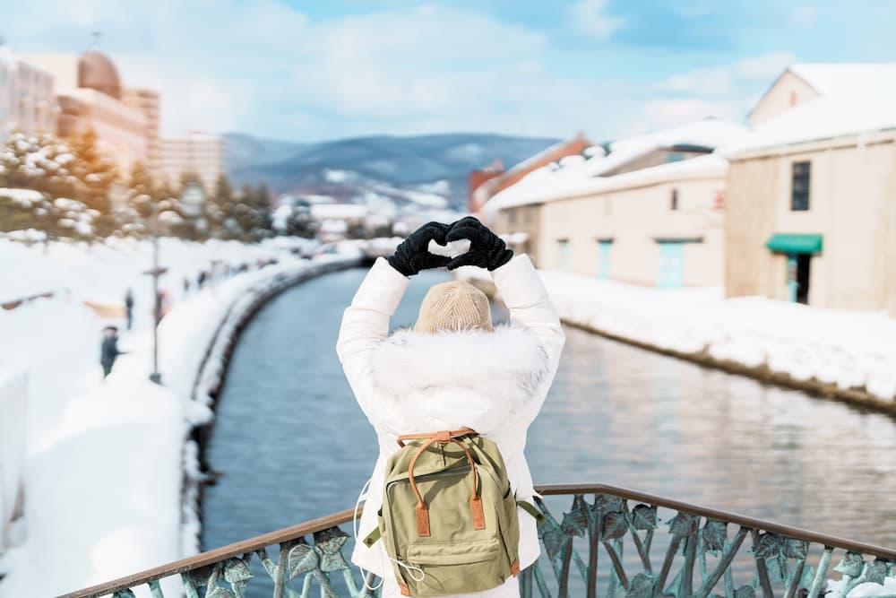 Turister på sightseeing langs den snedækkede Otaru-kanal i Hokkaido, Japan, nyder vintersæsonen.