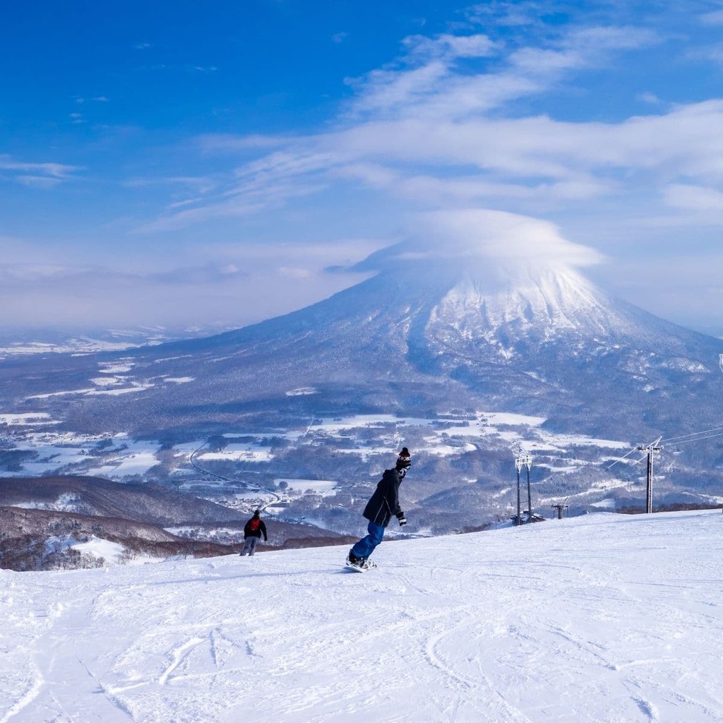 Sneklædt vulkan med skyhætte set fra et skisportssted (Niseko, Hokkaido, Japan)