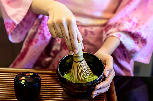 Dame i kimono laver japansk grøn te