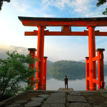 Turist ved den røde torii-port ved Hakone-helligdommen, der ligger ved Ashi-søen, Japan