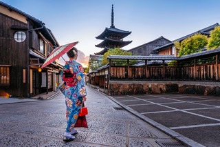 Kvinde i kimono med paraply i Kyoto 