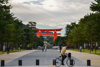En cyklist passerer den ikoniske Torii-port ved Heian-helligdommen i Kyoto