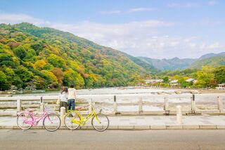 Et par nyder en pause under cykelturen i Kyoto med udsigt over Hozu-floden 