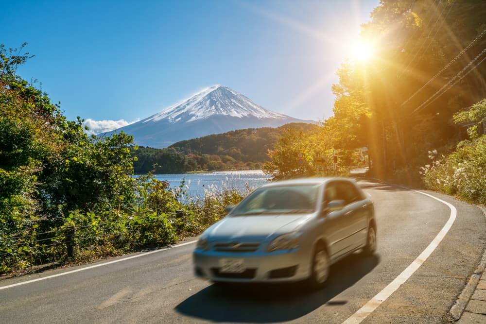 Bil i nærheden af Fuji-bjerget i Japan med bevægelsessløring, der viser hurtig bevægelse på en motorvej ved Kawaguchiko-søen